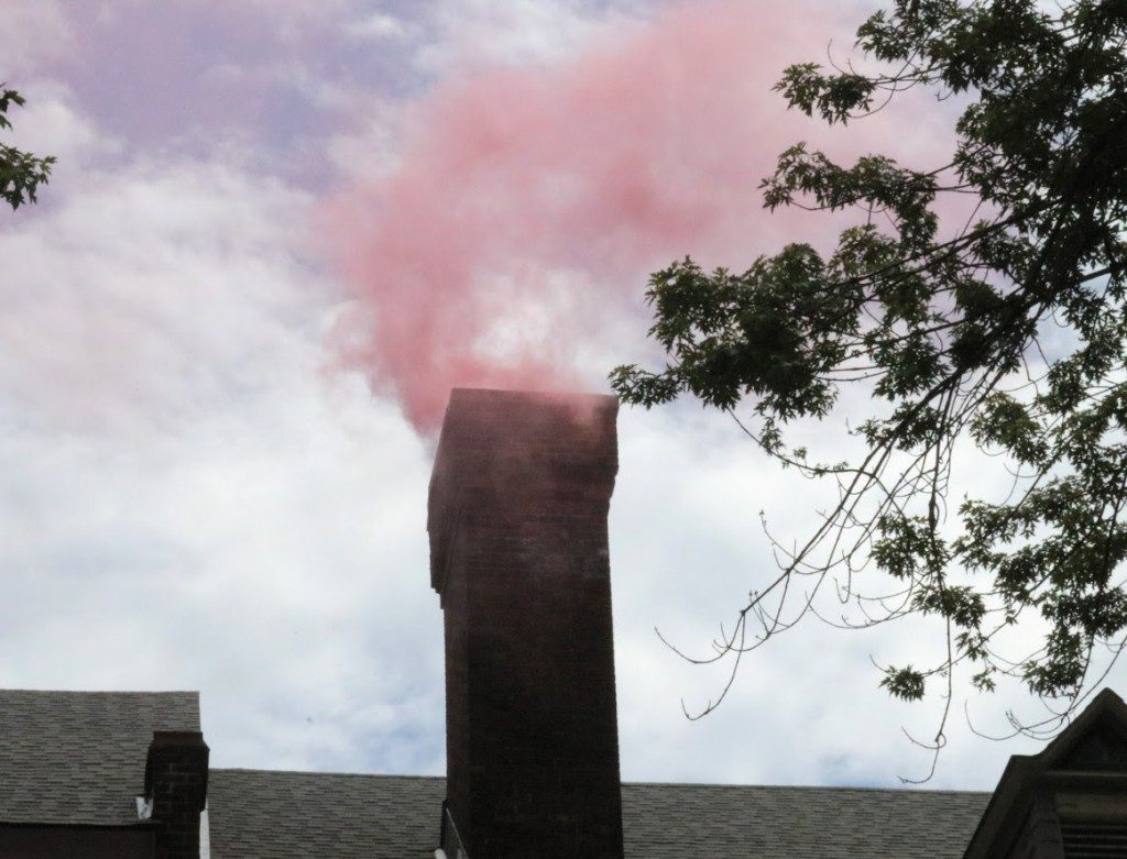 Pink smoke coming from smoke stack.
