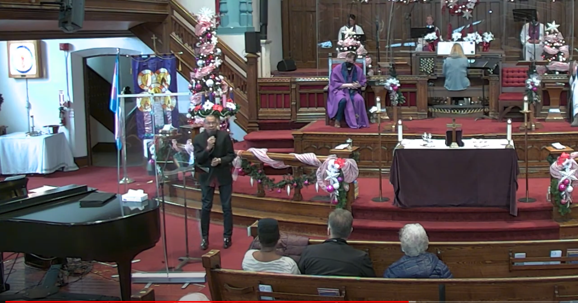 Photo of our Sunday Service: Billy Newton-Davis Ssinging and Jeff Rock sitting behind him in the Sanctuary.