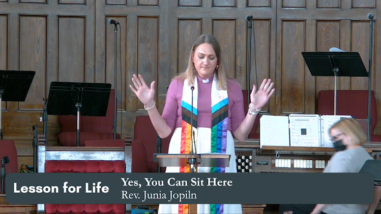 Rev. Junia Joplin speaking at the pulpit with text saying Lesson for life. Yes, You can sit here.