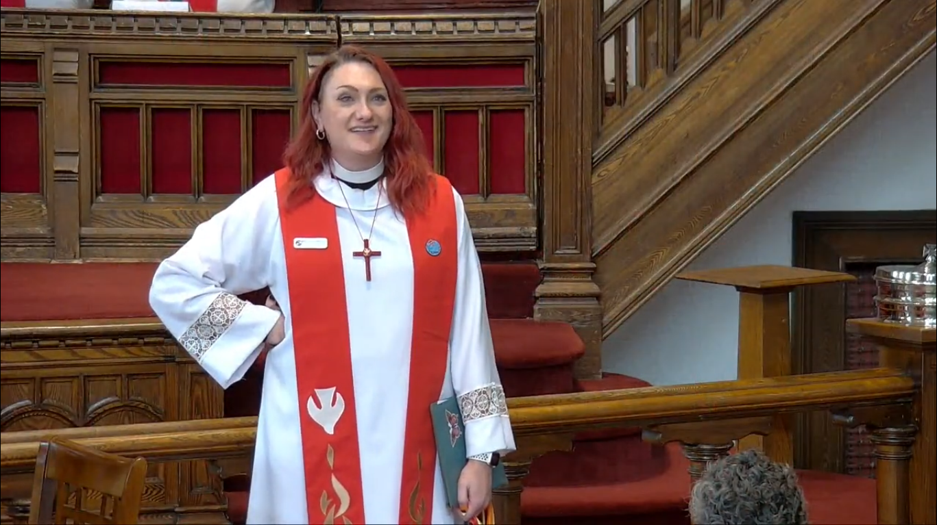 Picture of Rev. June standing in the sanctuary of MCC Toronto.