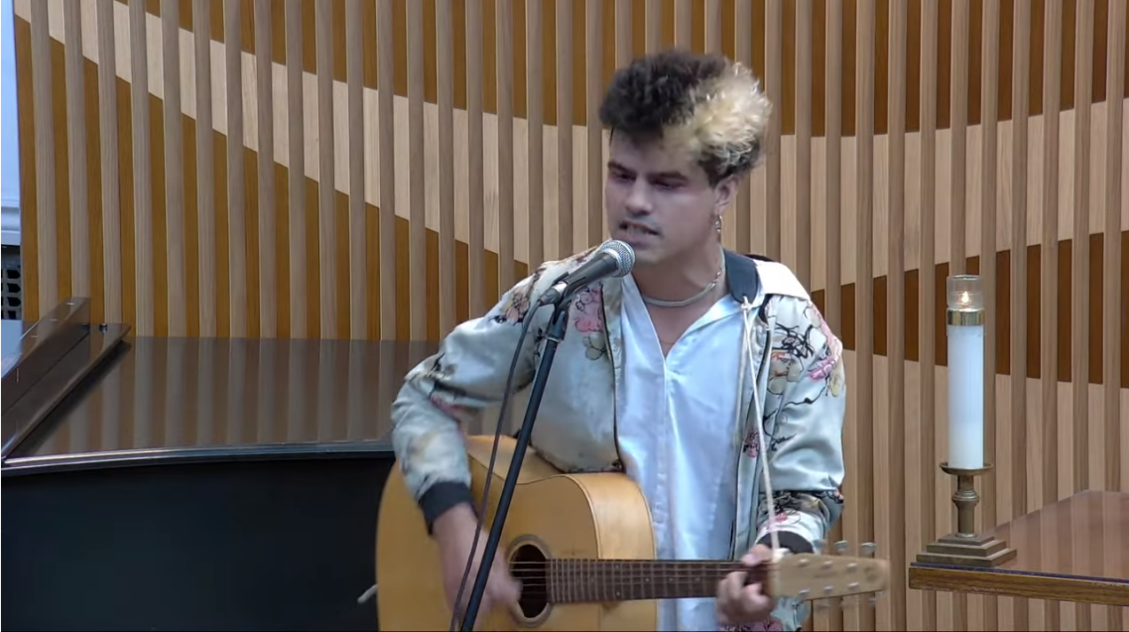 Picture of CJ singing and playing guitar