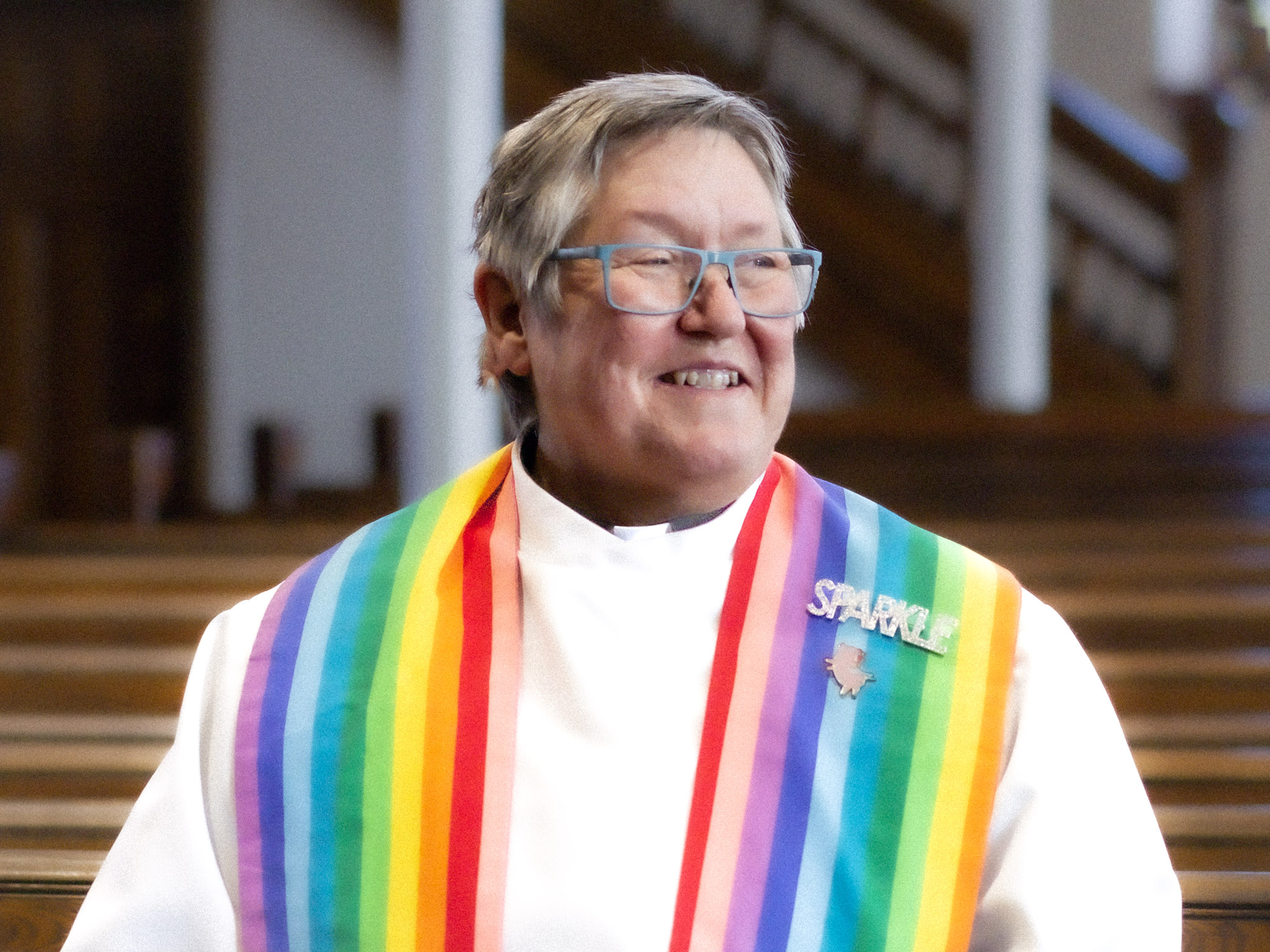 Head shot of Rev. Deana waring a rainbow stole